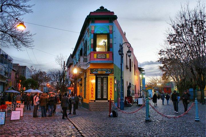 <h3>LA BOCA Y EL CAMINITO</h3>Este colorido barrio es famoso por sus casas pintadas de colores vibrantes y la calle peatonal Caminito, bordeada de vendedores de arte, espectáculos de tango y restaurantes. Es un punto cultural de referencia donde los visitantes pueden experimentar la esencia del tango argentino y el arte local.