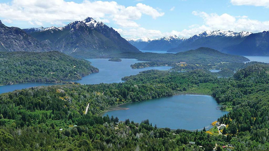 <h3>NAHUEL HUAPI NATIONAL PARK </h3>Spanning over 7,050 square kilometers, Nahuel Huapi National Park is the oldest national park in Argentina, established in 1934. It is centered around the Nahuel Huapi Lake, which offers stunning views of crystal-clear waters against the backdrop of the Andes mountains. The park is a haven for outdoor enthusiasts, offering activities such as hiking, kayaking, and fishing. With diverse flora and fauna, visitors can spot native species like the Andean condor and the pudú, the world's smallest deer. Scenic trails like the Frey Refuge and the Tronador Volcano provide breathtaking vistas and immersive experiences in Patagonia’s rugged wilderness.