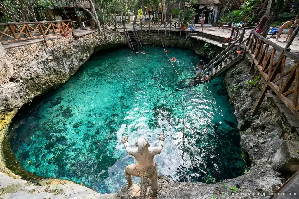 <h3>CENOTES</h3>Los cenotes son sumideros naturales encontrados a lo largo de la península de Yucatán en México, incluyendo cerca de Tulum, y tienen una gran importancia geológica y cultural. Estas piscinas de agua dulce se forman durante millones de años a medida que el lecho de roca de piedra caliza colapsa, exponiendo el agua subterránea debajo. Los cenotes varían en tamaño y forma, desde piscinas al aire libre rodeadas de vegetación exuberante hasta estructuras tipo cueva con ríos subterráneos y estalactitas. Son venerados por los antiguos mayas como portales sagrados al inframundo (Xibalba) y fueron fuentes vitales de agua dulce en el entorno denso de la selva de la región. Hoy en día, los cenotes atraen a los visitantes por sus aguas cristalinas, ideales para nadar, hacer snorkel y bucear entre formaciones naturales impresionantes. Ofrecen una oportunidad única para explorar las maravillas geológicas de la península y conectarse con su rica herencia cultural.