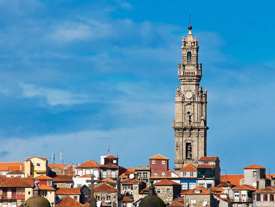 <h3>A Torre dos Clérigos e a Igreja dos Clérigos</h3>A Torre dos Clérigos é o icônico campanário do Porto, oferecendo vistas panorâmicas da cidade após uma subida por sua estreita escadaria em espiral. Ao lado, encontra-se a Igreja dos Clérigos, uma impressionante obra-prima barroca conhecida por seu interior ornamentado e importância histórica.