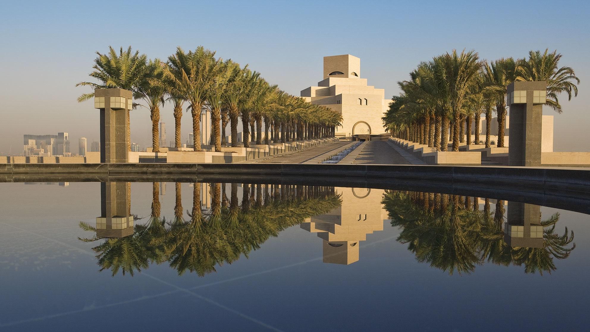 <h3>MUSEUM OF ISLAMIC ART</h3>The Museum of Islamic Art (MIA) in Doha stands as a prominent cultural landmark designed by renowned architect I.M. Pei. Located on its own island in Doha Bay, the museum houses an extensive collection of Islamic art spanning over 1,400 years and representing diverse regions from Spain to Southeast Asia. The MIA's impressive collection includes manuscripts, textiles, ceramics, metalwork, and glassware, showcasing the artistic achievements of Islamic civilizations. The museum's architecture itself is a blend of modern design and Islamic influences, featuring geometric patterns and a striking facade. Visitors can explore the museum's galleries, enjoy panoramic views of the Doha skyline from its atrium, and appreciate the significance of Islamic art and culture through its carefully curated exhibitions and educational programs.