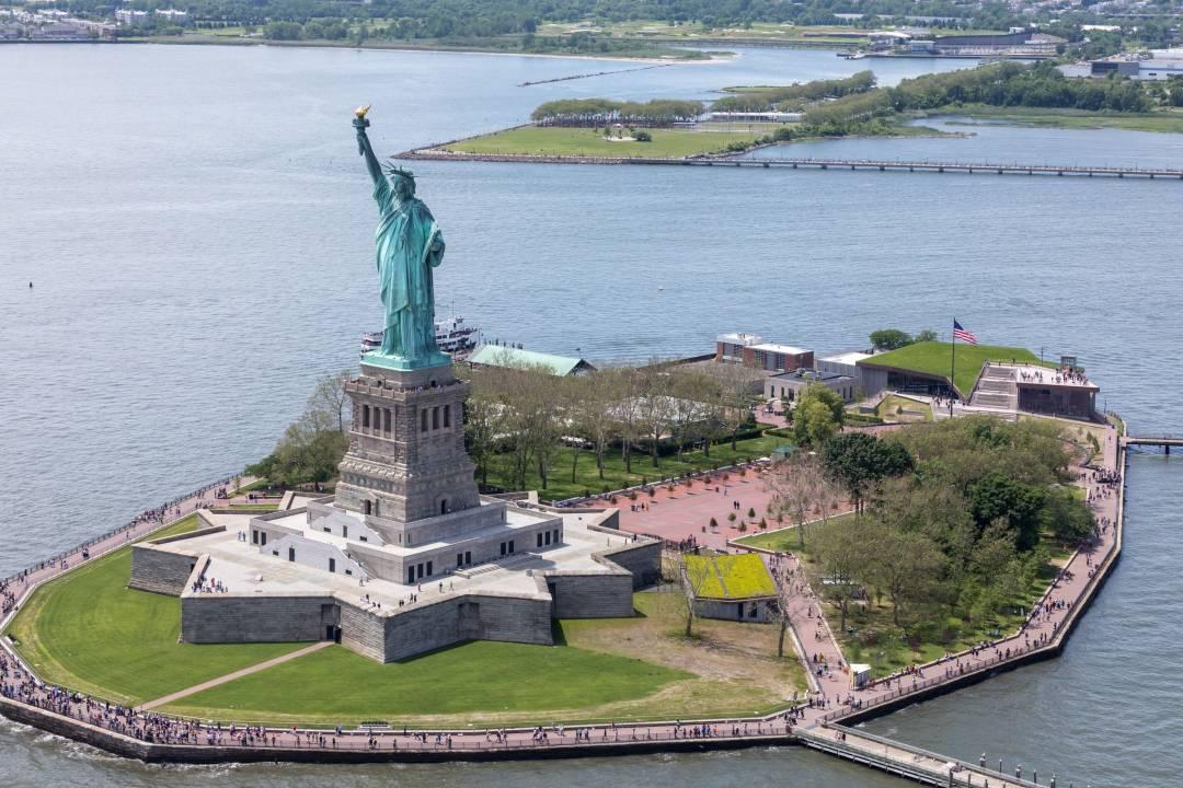 <h3>STATUE OF LIBERTY AND ELLIS ISLAND</h3>The Statue of Liberty and Ellis Island stand as enduring symbols of freedom, hope, and the immigrant experience in the United States. Located in New York Harbor, the Statue of Liberty, a gift from France in 1886, represents liberty and welcomes visitors with its iconic torch held high. Ellis Island, situated nearby, served as the primary immigration processing center from 1892 to 1954, where over 12 million immigrants entered the United States seeking a new life. Today, visitors can take ferries to both landmarks, explore the Statue of Liberty Museum to learn about its history and significance, and visit the Ellis Island National Museum of Immigration to discover personal stories and artifacts that illuminate America's diverse heritage and the journey of millions who shaped the nation. 